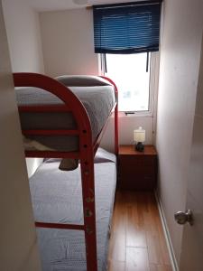 a small room with two bunk beds and a window at Departamento, Apartamento económico en La Serena in La Serena