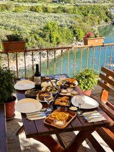 un tavolo in legno con cibo e vino sul balcone di Hotel Kalaja a Shkodër