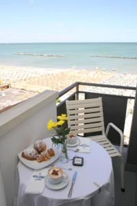 un tavolo con cibo su un balcone con vista sulla spiaggia di Hotel Levante Sul Mare a Lido di Savio