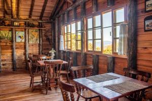 a dining room with tables and chairs and windows at Hotel e Pousada Montanha Real in Urubici