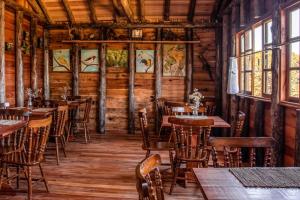 a restaurant with wooden tables and chairs and windows at Hotel e Pousada Montanha Real in Urubici