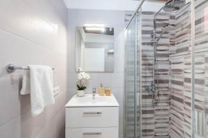 a white bathroom with a sink and a shower at Estudio House Los Llanos in La Esquinita