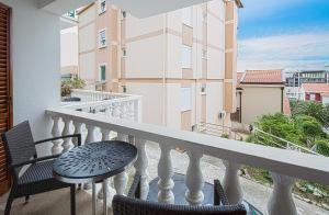 a balcony with a table and chairs and a building at Apartment Family in Petrovac na Moru