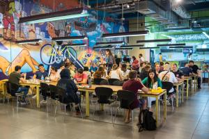a group of people sitting at tables in a restaurant at Abraham Tel Aviv in Tel Aviv