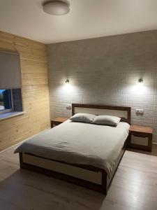 a bedroom with a large bed and two night stands at Fest House in Svityazʼ