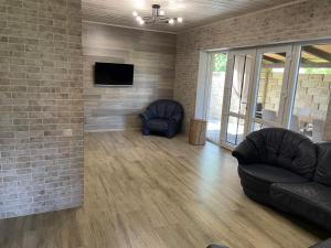 a living room with a couch and a tv on a brick wall at Fest House in Svityazʼ