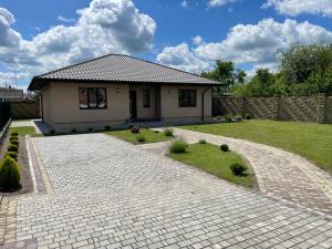 a house with a brick walkway in front of a yard at Fest House in Svityazʼ