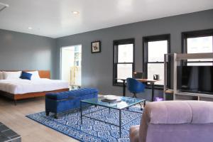 uma sala de estar com uma cama, um sofá e uma mesa em Good Hotels Downtown Denver em Denver