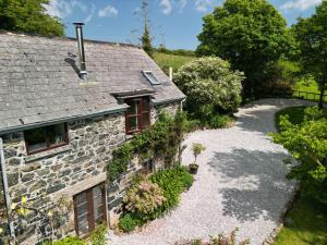 an external view of a stone house with a gravel driveway at Higher Lampra in Helston