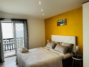 a bedroom with a large bed with a yellow wall at Apartmani Mutogras in Podstrana