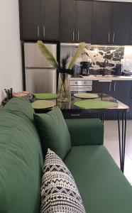 uma sala de estar com um sofá verde e uma mesa em Enigma Boutique Houses Vraxos em Marmari