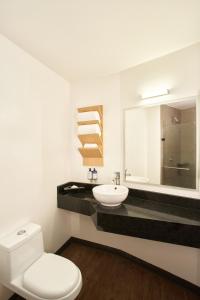 a bathroom with a toilet and a sink and a mirror at GAMMA Querétaro in Querétaro