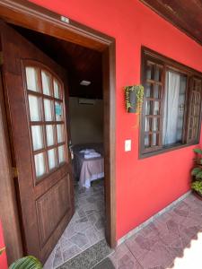 una stanza con una parete rossa e una porta di Pousada Convés - Ilha Grande a Praia de Araçatiba