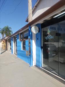 um edifício azul com um sinal de basquetebol na janela em Renoah Pousada em Ubatuba