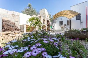 a garden with purple flowers in front of a building at Villetta Mariangela in Capilungo