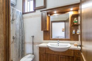 a bathroom with a sink and a toilet and a mirror at Villetta Mariangela in Capilungo