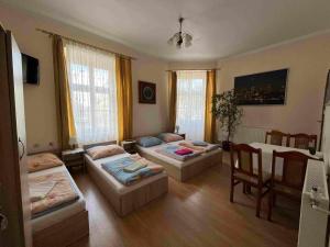 a living room with three beds and a table at Green Hostel in Krakow