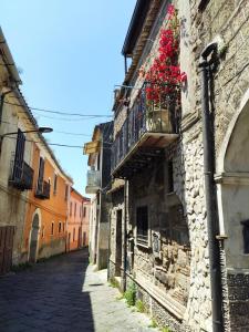 Vicolo degli Osci في كازيرتا: زقاق مع شرفة مع الزهور على مبنى