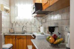 a kitchen with a bowl of fruit on a counter at Nature Village Apartment in Áyioi Dhéka