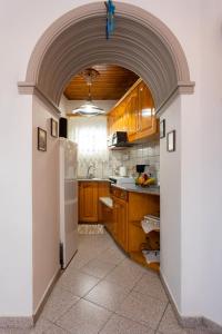 an archway in a kitchen with wooden cabinets at Nature Village Apartment in Áyioi Dhéka