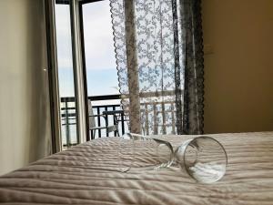 a pair of glasses sitting on a bed in front of a window at Apartmani Mutogras in Podstrana