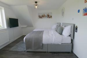 a bedroom with a bed with white sheets and pillows at Isabella Rooms in Hockley