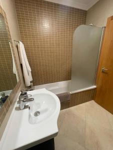 a bathroom with a white sink and a shower at Cricket Apartments in Ferrel