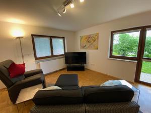 uma sala de estar com um sofá e uma televisão em ALB 74 em Waldbronn