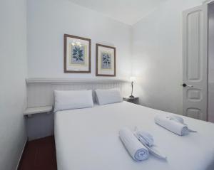 a white bed with two pillows on top of it at Stay U-nique Apartments Rogent in Barcelona