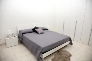 ein Schlafzimmer mit einem Bett und einer weißen Wand in der Unterkunft Malì Casa Vacanze in Neapel