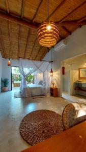 a large room with a large bed and a chandelier at Vila dos Macacos Trancoso in Trancoso