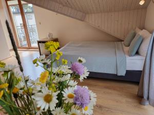 una camera con un letto e un mazzo di fiori di Willa Jack 4 a Władysławowo