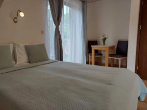 una camera da letto con un grande letto bianco e una finestra di Willa Jack 4 a Władysławowo