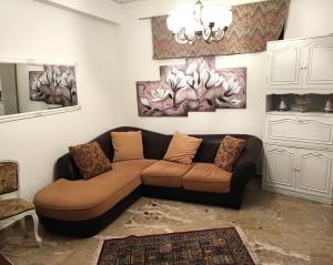 ein Wohnzimmer mit einem braunen Sofa und Gemälden an der Wand in der Unterkunft Dai Maestri Rubino in Vita