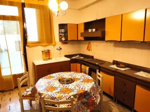 eine Küche mit einem Tisch mit gemustertem Tischtuch in der Unterkunft Dai Maestri Rubino in Vita