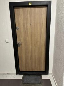 een houten deur met een bord erop in een kamer bij Welcoming Apartment w/ Wi-Fi + Private Bathroom in Struga