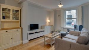 a living room with a couch and a tv at Woodville Road, Mumbles in The Mumbles