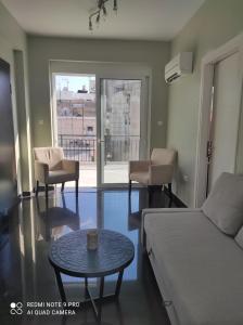 a living room with a couch and a table at Katia's sunny penthouse apartment in Piraeus