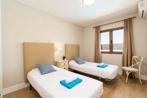 2 camas individuales en una habitación con ventana en Villa Caleta Heights by Villa Plus, en Caleta de Fuste