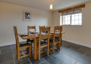 a dining room with a wooden table and chairs at Llys Bach in Llanarmon