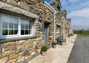 a stone building with a door and a window at Llys Bach in Llanarmon