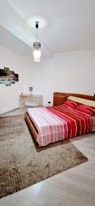 1 dormitorio con 1 cama con manta roja y blanca en Casa Karmèl en Porto Torres