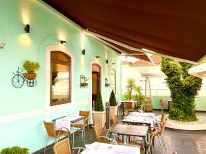 a restaurant with tables and chairs in front of a building at Salero Guest House in Loures