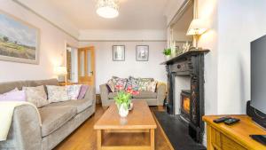 a living room with a couch and a fireplace at Ivy Dene in Crich
