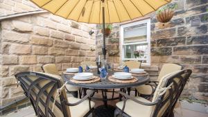 a table with chairs and a yellow umbrella at Ivy Dene in Crich