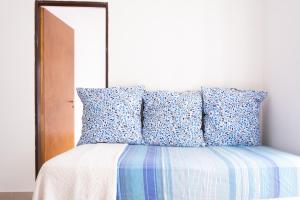 Cama con sábanas y almohadas azules y blancas en Hermoso Apartamento a estrenar en Buenos Aires