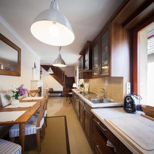 kuchnia z drewnianymi szafkami, zlewem i stołami w obiekcie Apartment House 41 w mieście Sopron