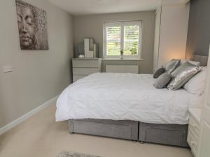 a bedroom with a large white bed and a window at 1 Old Farm Court in Barnstaple