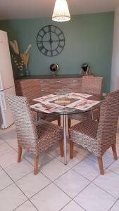 a dining room table with chairs and a clock on the wall at les galipes in Hautvillers +11 photos