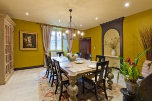 uma sala de jantar com paredes amarelas e uma mesa e cadeiras em A l'Ombre du Château em Nans-sous-Sainte-Anne